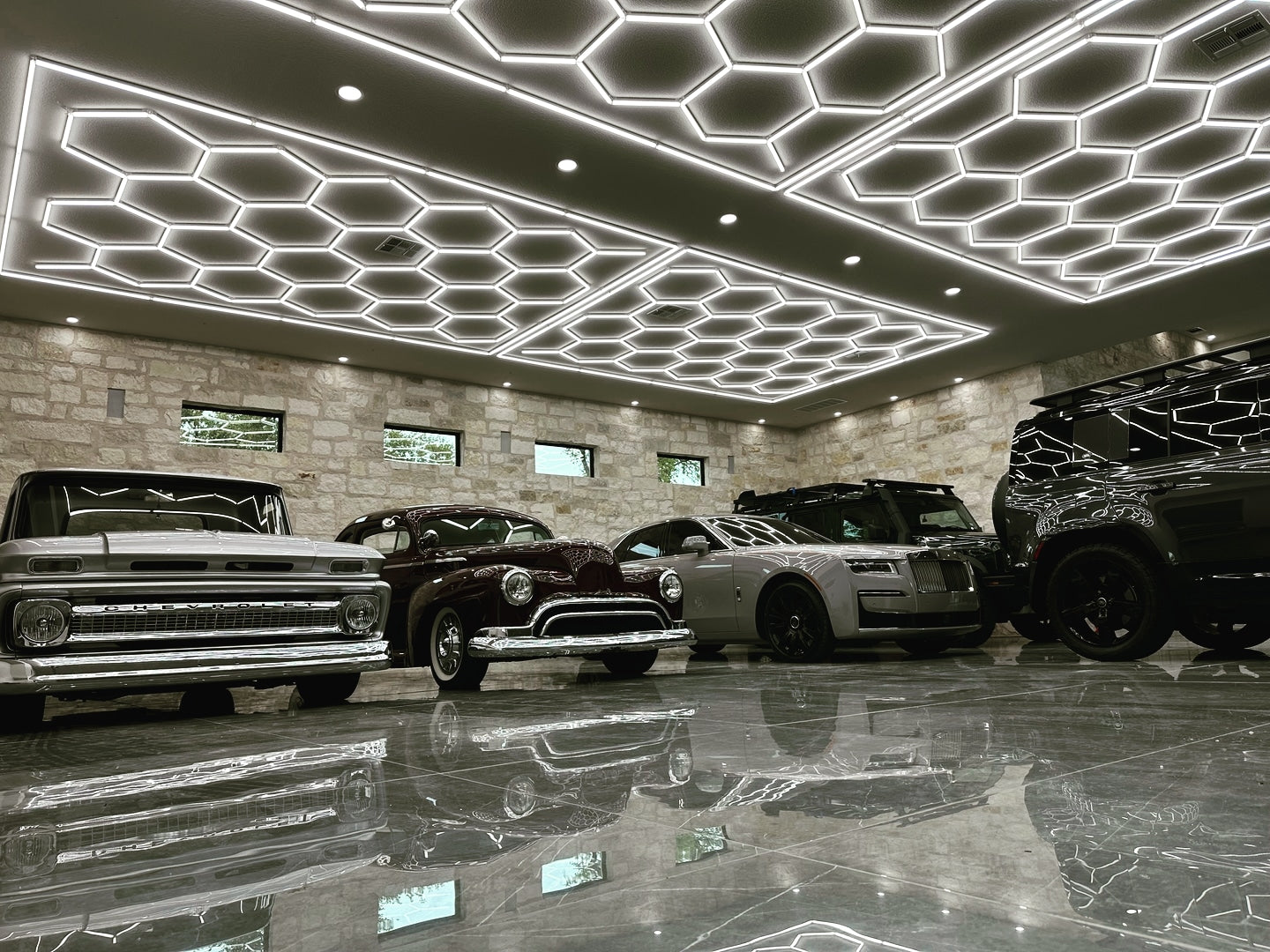 Hex garage lighting in modern garage with 1965 Chevrolet C10 pickup truck, Rolls-Royce, 1950s Series 88 Oldsmobile