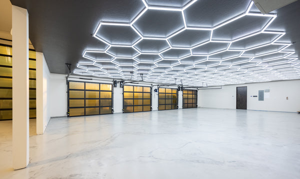 Hexagon garage lighting in 5 car garage with glass garage doors and white epoxy floors