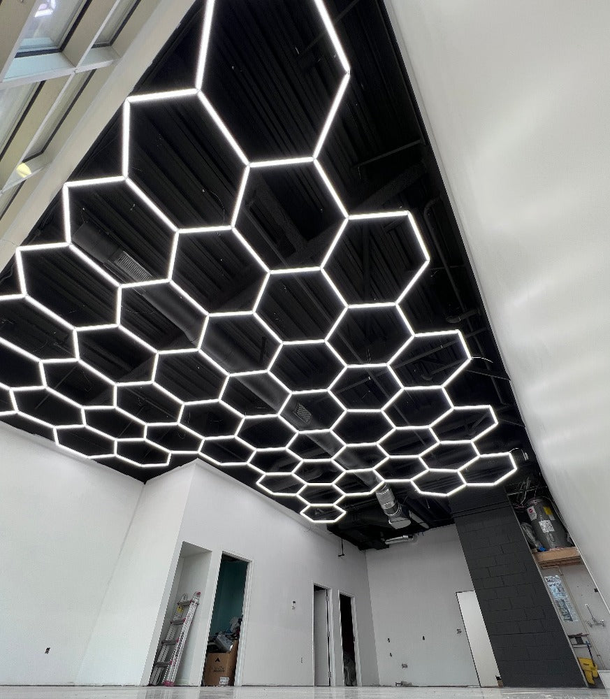 Large hexagon LED grid installed on a black ceiling in a newly finished garage