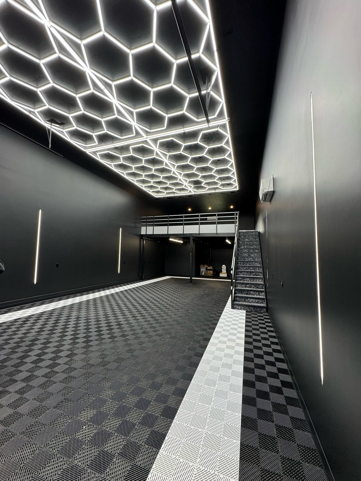 Hexagon light grid over a checkered floor in a black garage condo; 24V dimmable hexagon lights with remote
