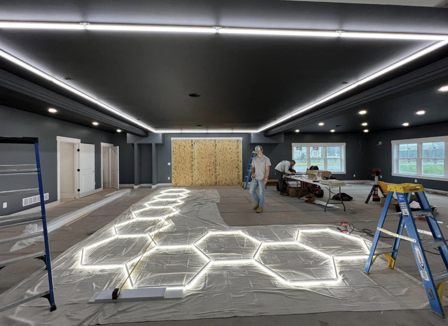 Installers snapping a hexagon light grid together on the floor before hanging it